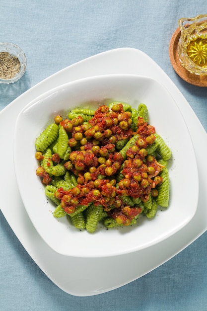 Gnocchi di pasta fresca tradizionale sarda italiana con spinaci e salsa di pomodoro verde piselli.