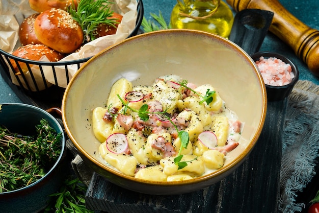 Gnocchi di patate con pancetta e panna acida Su fondo di pietra nera Pane