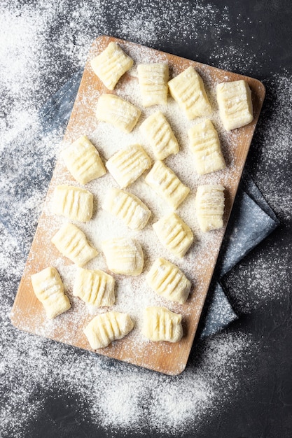 Gnocchi di patate fatti in casa crudi con farina sul tagliere