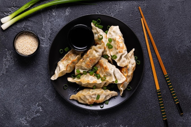 Gnocchi fritti Gyoza su un piatto su uno sfondo di cemento grigio