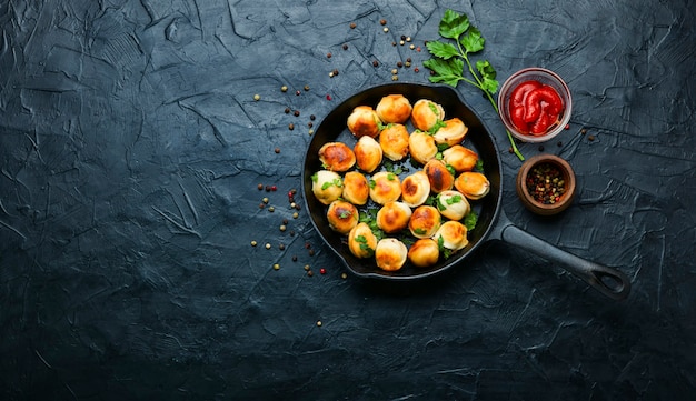 Gnocchi fritti ripieni di carne di manzo. Gustosi pelmeni arrostiti su padella in ghisa