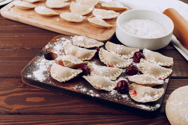 Gnocchi russi ripieni crudi sul bordo di legno