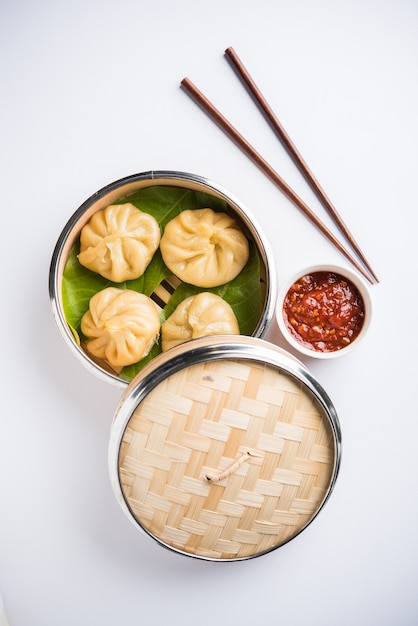 Gnocchi tradizionali momos cibo dal Nepal servito con chutney di pomodoro su sfondo lunatico. Messa a fuoco selettiva