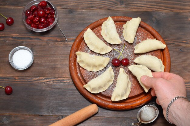 Gnocchi tradizionali ucraini con ciliegie e una mano d39uomo