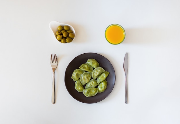 Gnocchi vareniki tradizionali russi e ucraini vegetariani, con olive e succo d'arancia. Vista dall'alto.