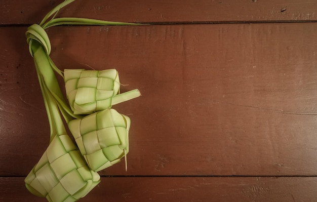 Gnocco di riso Ketupat su sfondo di legno Ketupat è un tipico piatto indonesiano su eid Mubarak