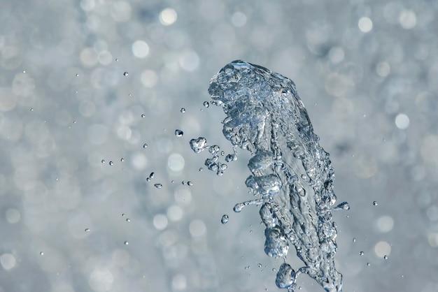 Gocce d'acqua blu della fontana nel cielo