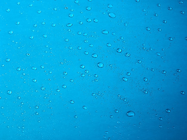 Gocce d'acqua casuali sulla superficie in PVC blu