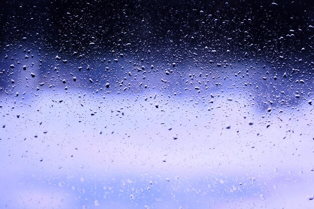 Gocce d'acqua di sfondo blu sul vetro