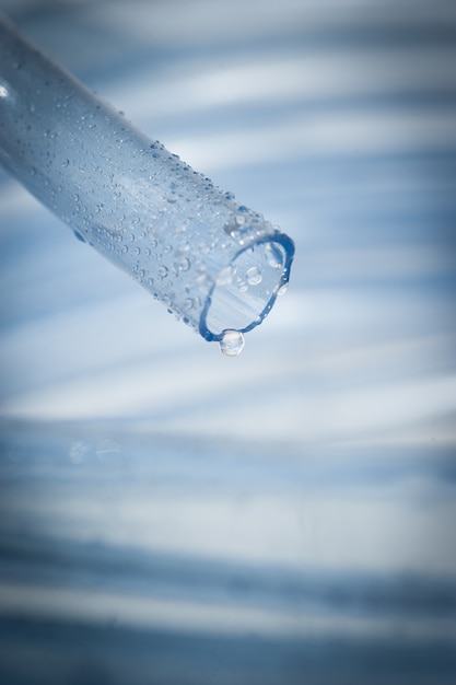Gocce d&#39;acqua gocciolano dal tubo da giardino blu