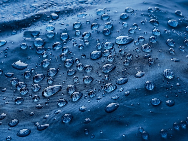 Gocce d'acqua piovana su tessuto impermeabile.
