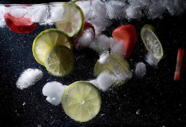 Gocce d'acqua su frutti dolci maturi e bacche. Sfondo di frutta fresca con copia spazio per il testo. Concetto vegano e vegetariano.