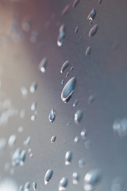 Gocce d&#39;acqua su sfondo metallico blu.