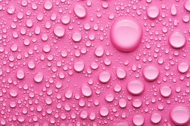 Gocce d'acqua su sfondo rosa