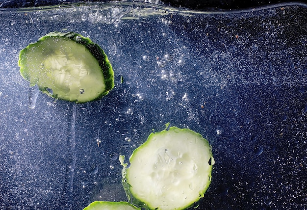 Gocce d'acqua sul cetriolo maturo. Sfondo di verdure fresche con copia spazio per il testo. Concetto vegano e vegetariano.