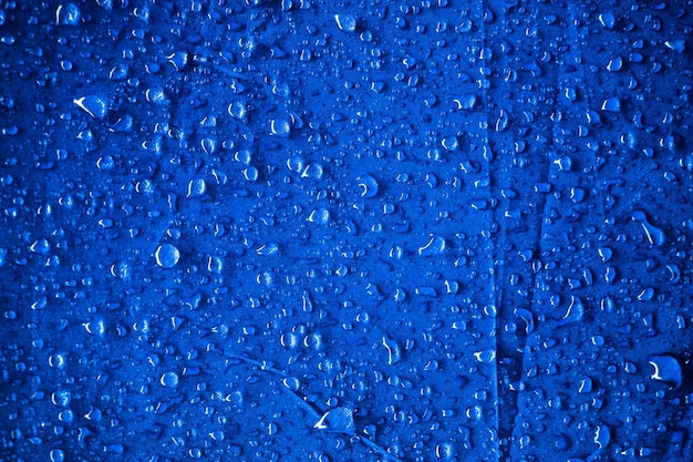 Gocce d'acqua sul tessuto blu Gocce d'acqua su sfondo blu