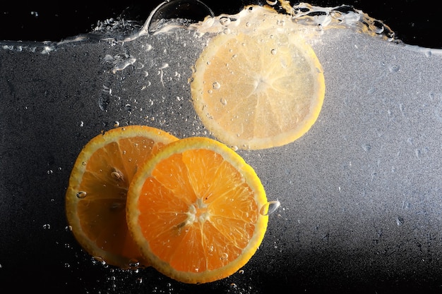 Gocce d'acqua sull'arancia dolce matura. Sfondo mandarino fresco con copia spazio per il testo. Concetto vegano e vegetariano.