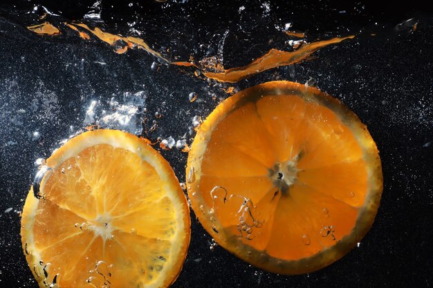 Gocce d'acqua sull'arancia dolce matura. Sfondo mandarino fresco con copia spazio per il testo. Concetto vegano e vegetariano.