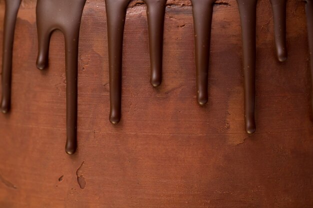 Gocce di cioccolato sullo sfondo di ganache al cioccolato fondente