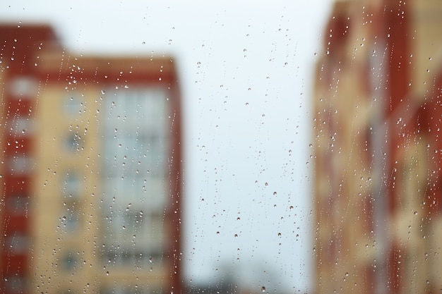Gocce di pioggia sulla finestra contro la città