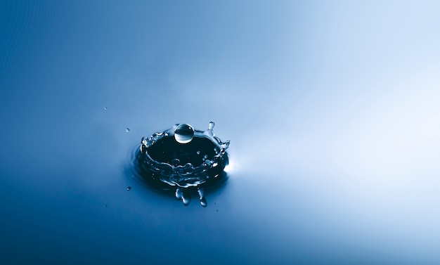 Goccia d&#39;acqua blu che cade e cerchi onda.