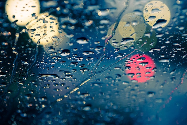 goccia d&#39;acqua sul vetro anteriore della macchina con luce bokeh per lo sfondo