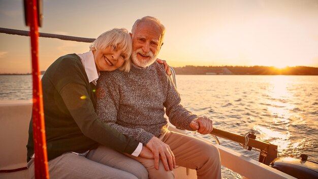 Godendo di un tramonto incredibile felice coppia anziana uomo e donna anziani che si tengono per mano abbracciando e