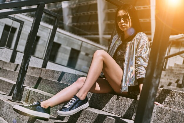Godendo una bella giornata. Bella giovane donna asiatica in abbigliamento casual che guarda l'obbiettivo