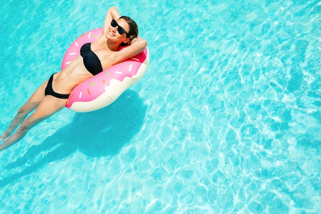 Godere della donna abbronzatura in bikini sul materasso gonfiabile