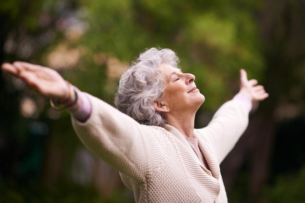 Godersi la pace e la tranquillità del suo giardino Inquadratura di una donna anziana che si gode la vita all'aria aperta