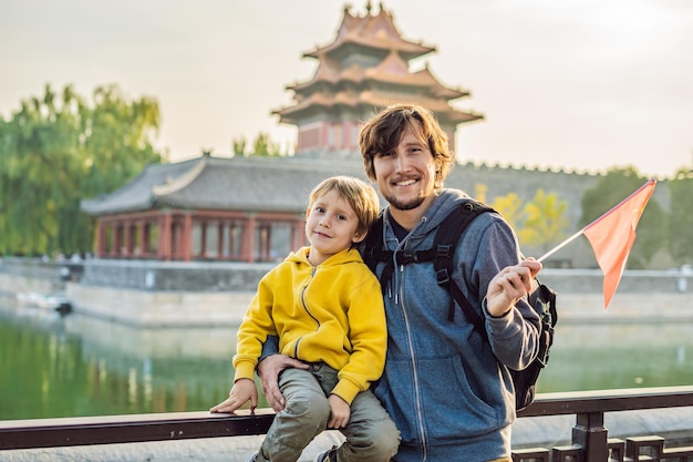 Godersi le vacanze in Cina Famiglia felice con bandiera nazionale cinese nella Città Proibita Viaggio in Cina con il concetto di bambini Transito gratuito 72 ore 144 ore in Cina