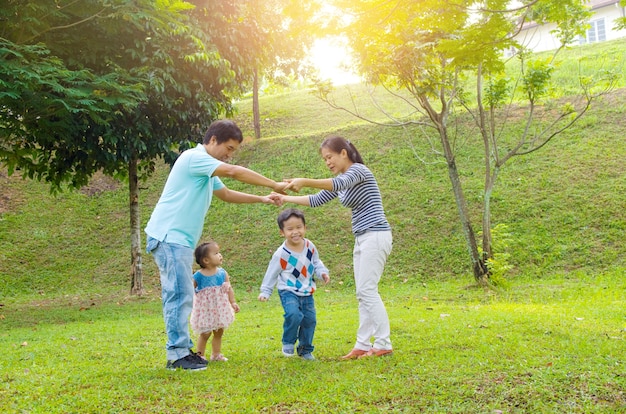 Godimento di tempo di qualità esterna della famiglia asiatica, gente asiatica che gioca durante il bello tramonto.