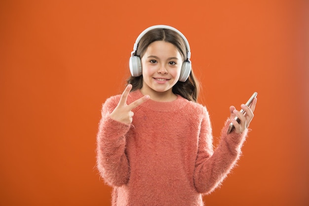 Goditi il concetto di musica Le migliori app musicali che meritano un ascolto Bambina ascolta musica cuffie e smartphone moderni Ascolta gratis Ottieni musica Abbonamento famiglia Accesso a milioni di brani