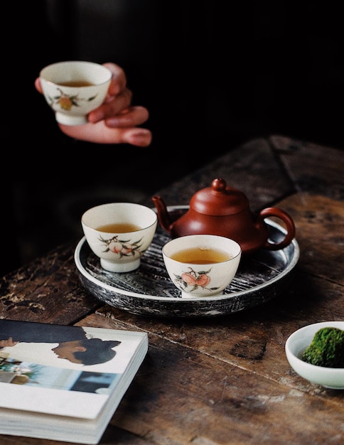 Goditi il tè a casa in un momento di relax Due tazze di tè con un piatto di torta su un tavolo di legno