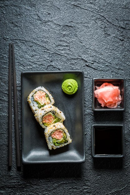Goditi il tuo sushi a base di salmone su roccia nera