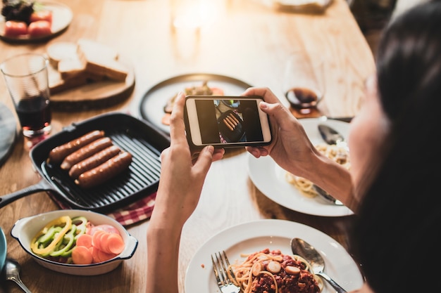 Goditi la cena mangiando festa e festeggiando con gli amici e scattando foto per telefono