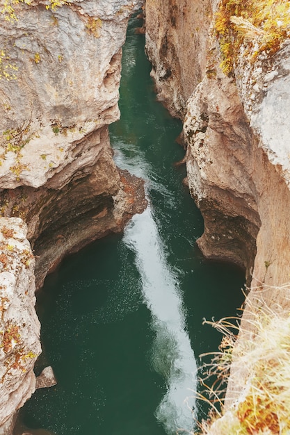 Gola con un fiume di montagna con una vibrante acqua turchese tra le rocce.