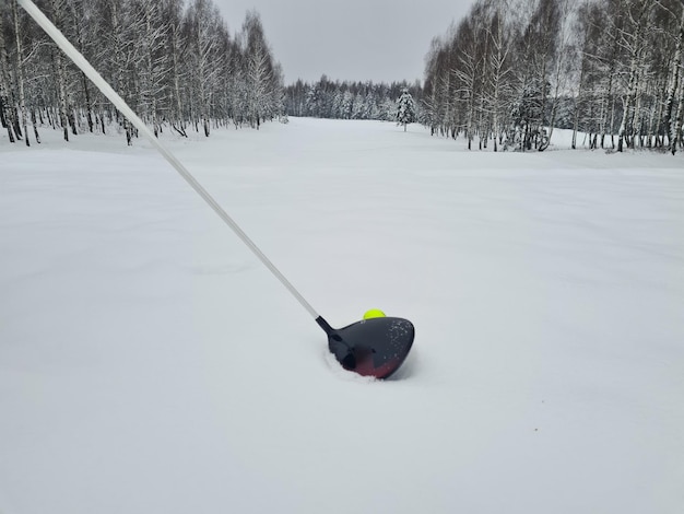 Golf club e pallina da golf in inverno sulla neve sul campo da golf