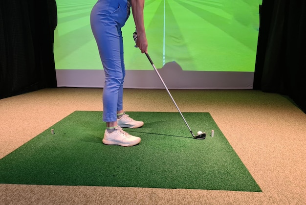 Golfer Swinging Club sullo schermo del simulatore nell'impostazione Modern Sport Club.