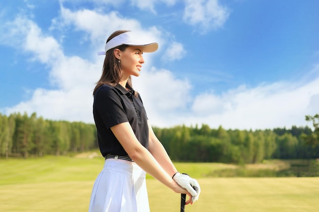 Golfista donna colpisce un fairway shot verso la club house.