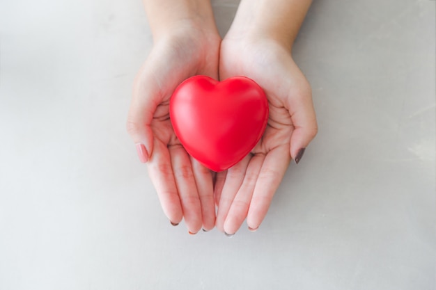 Gomma a forma di cuore rosso sulla bella mano di donna