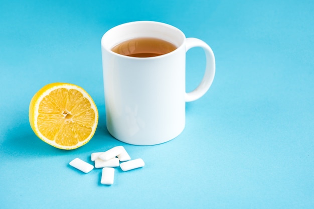 Gomma al limone e tazza di tè su sfondo blu. Pulizia e protezione dei denti.