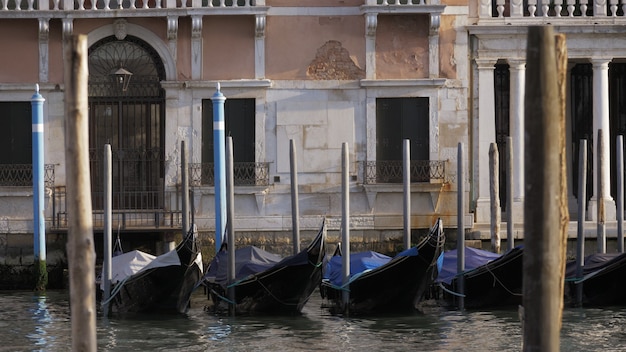 Gondole nere vuote che ondeggiano su un molo vicino alla bellissima facciata bianca