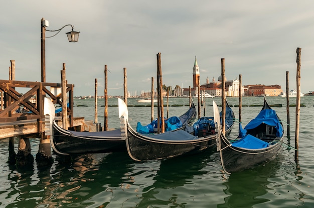 Gondole veneziane tradizionali che galleggiano sull'acqua in laguna sull'isola di San Giorgio