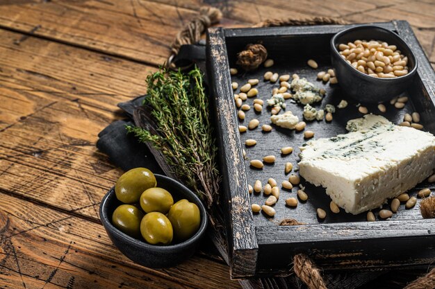 Gorgonzola in un vassoio di legno con olive e noci Sfondo in legno Vista dall'alto Copia spazio