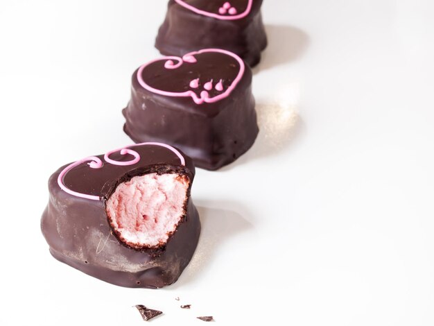 Gourmet cioccolato ricoperti di marshmallow alla fragola su sfondo bianco.