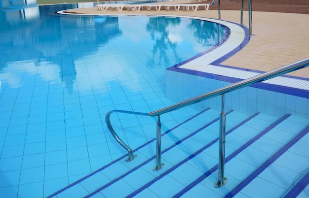 Grab bar scaletta nella piscina blu.