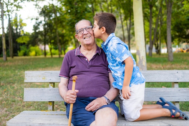 Gradson bacia suo nonno seduto su una panchina nel parco