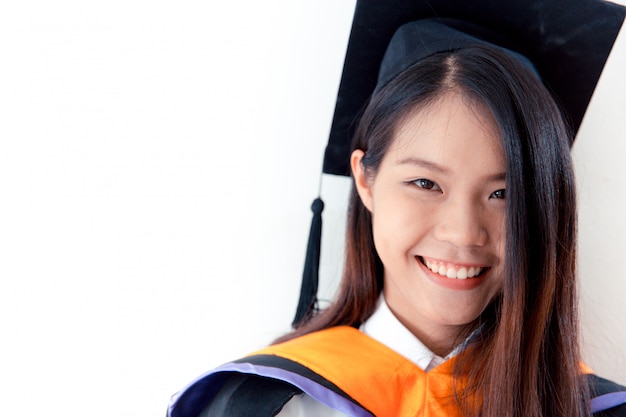 Graduazione sveglia asiatica del ritratto delle donne isolata su bianco, università della Tailandia.