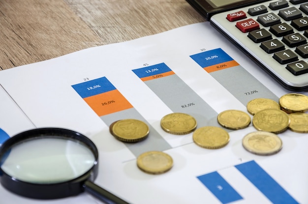 grafici aziendali e denaro su un tavolo di legno in ufficio contabilità fiscale statistica e analitica